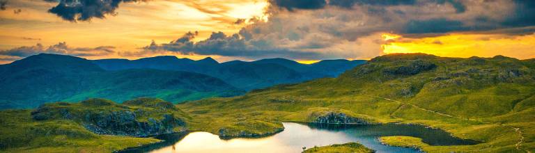 An image of a mountain tarn and view at sunset